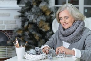 65629470 - portrait of senior woman sitting at the table with christmas decorations