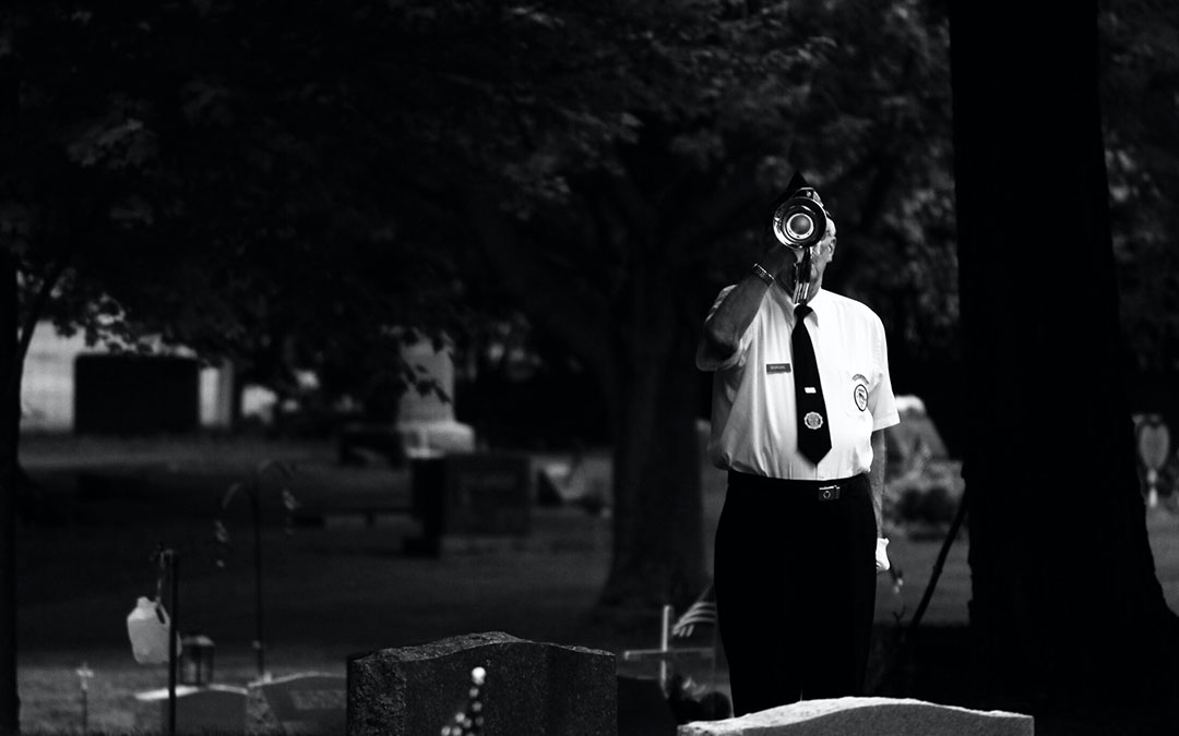 Soldier playing taps in a cemetery
